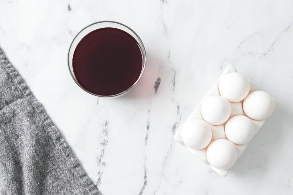 eggs sitting on a counter with beet juice in a bowl