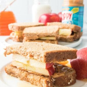 apple, peanut butter and honey sandwich on a white plate