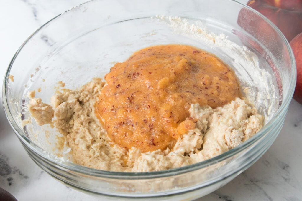peach puree on waffle mixture in bowl