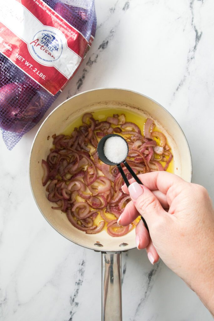 adding ingredients to saucepan with onions