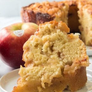 close up vertical shot of a slice of jewish apple cake recipe on a white plate