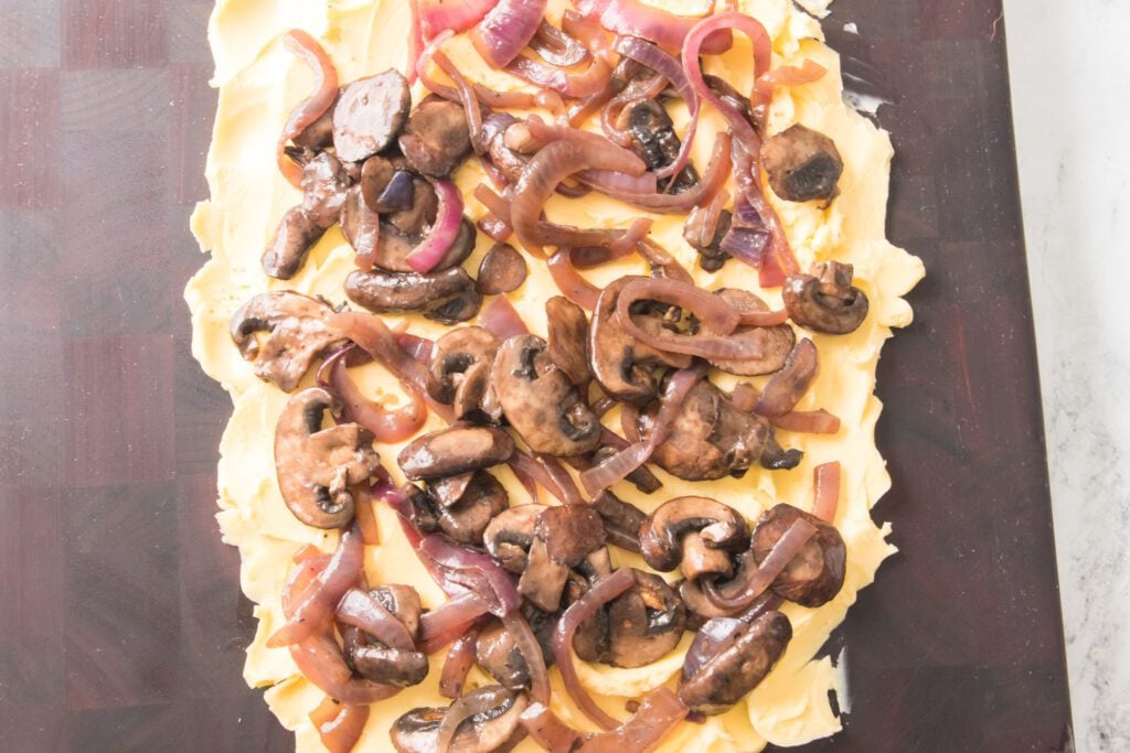 cutting board with butter, onions and mushrooms