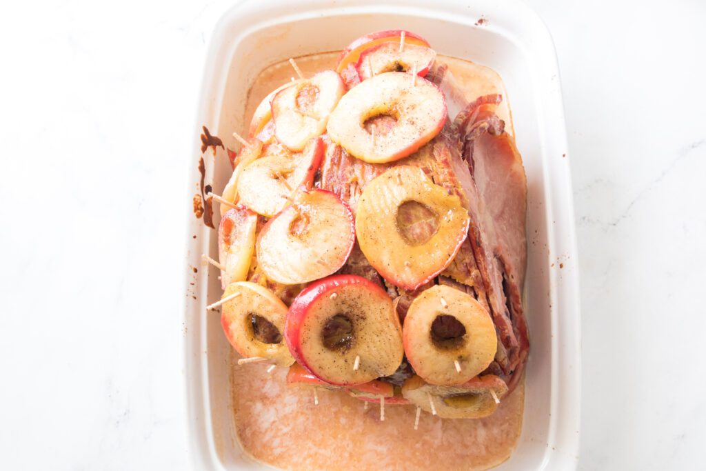 Cooked apple rings placed on ham