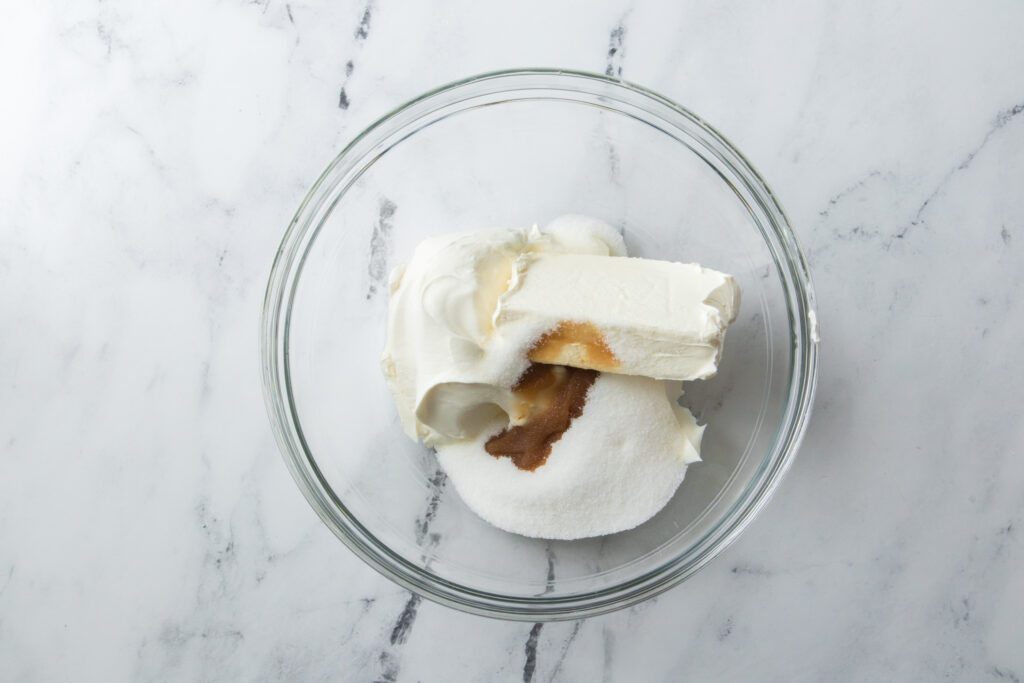cream cheese, sour cream, sugar and vanilla extract in glass bowl