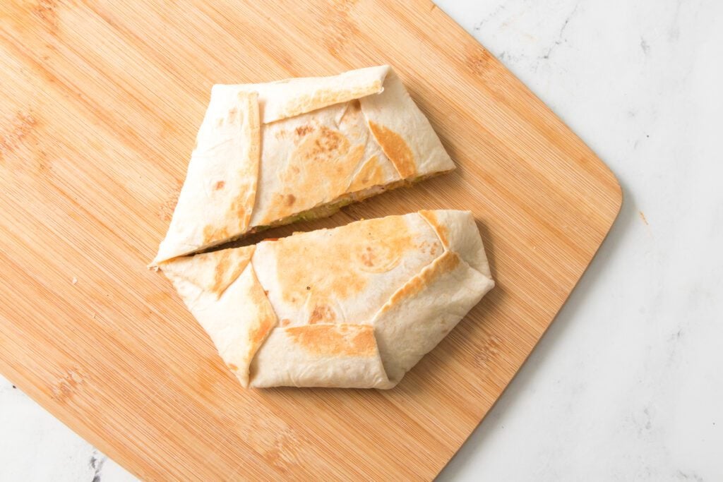 crunchwrap on cutting board cut in half