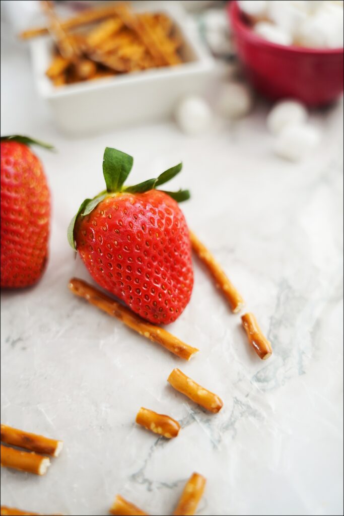 strawberry with pieces of broken pretzel sticks