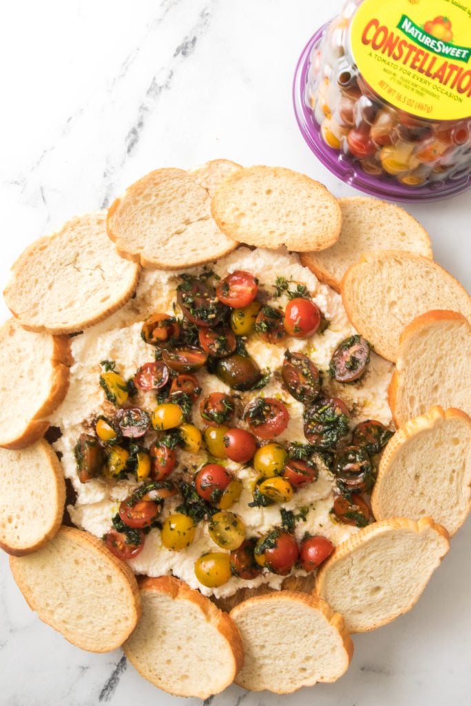 overhead vertical shot of ricotta bruschetta board with naturesweet constellation tomatoes