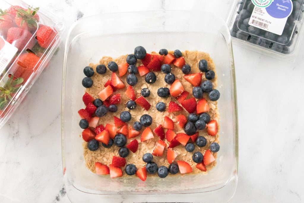 baking dish with fresh blueberries and strawberries on top of a oatmeal crust
