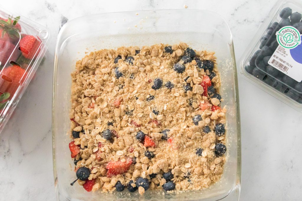 mixed berry crumble bar in glass pan previous to baking