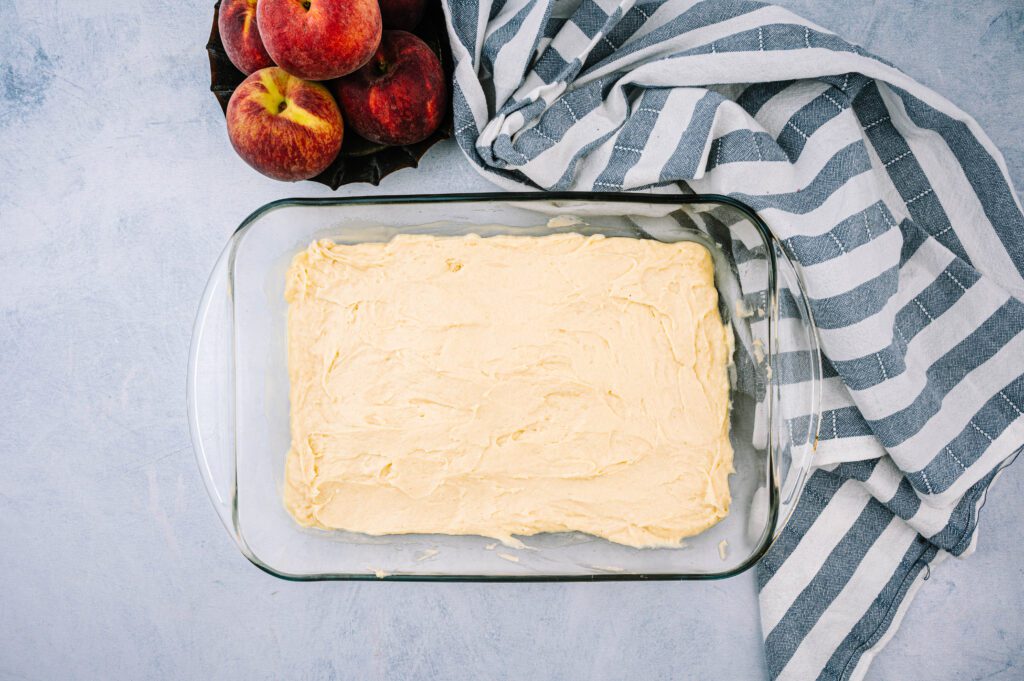 peach coffee cake batter in baking dish