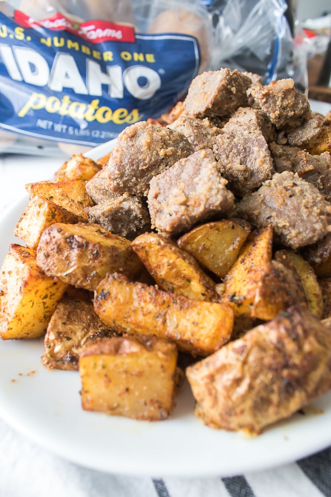 vertical image close up shot of crispy potatoes and cooked steak