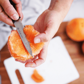 knife in grapefruit over cutting board