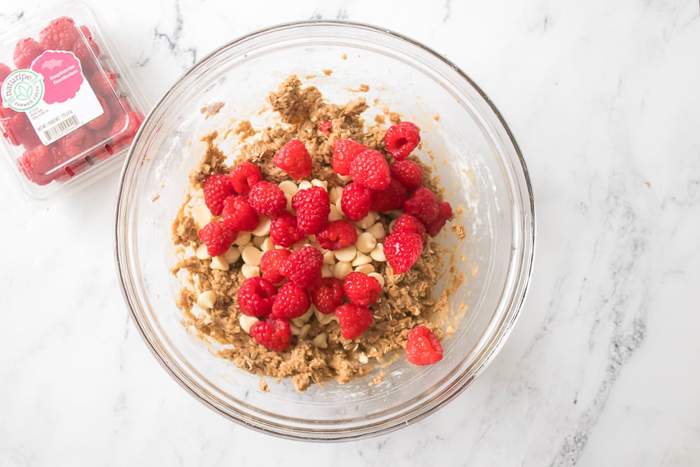 Adding in the white chocolate chips and Naturipe raspberries