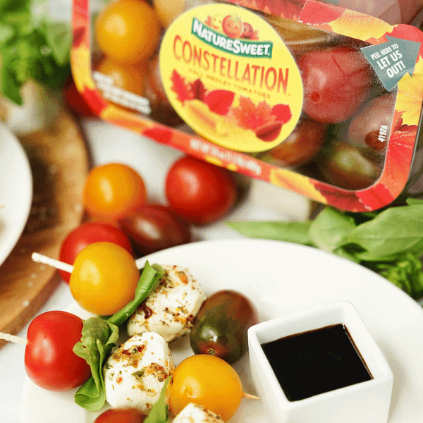 Caprese Skewers on plate surrounded by ingredients