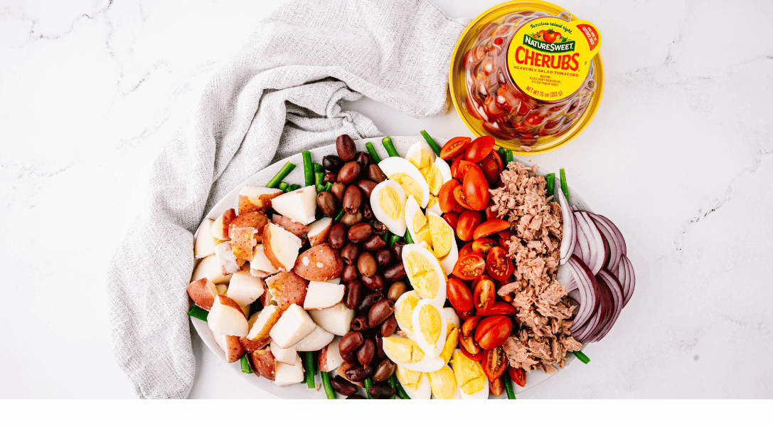 Plated Niçoise salad with Cherubs in background