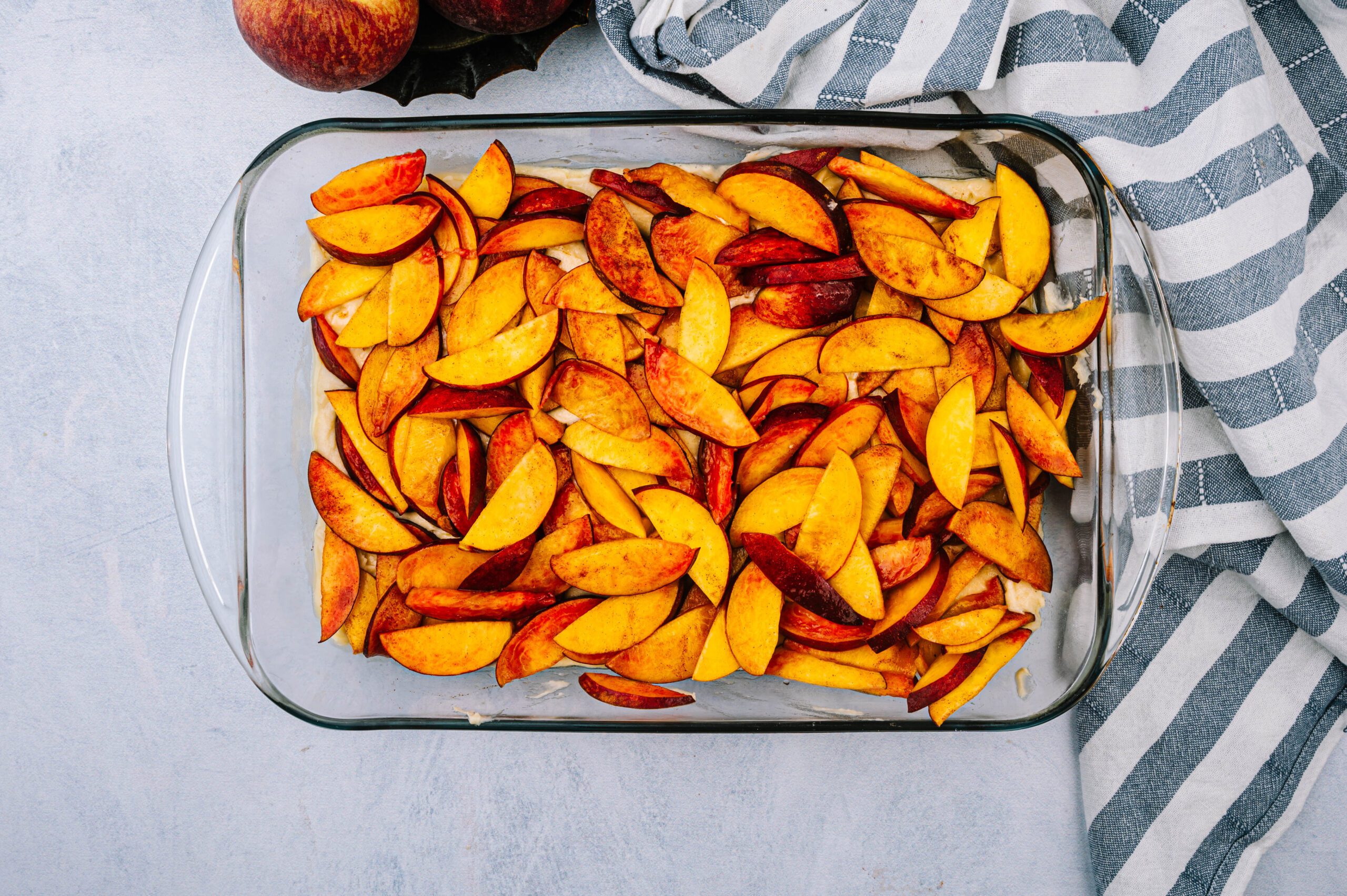 fresh peach slices topped on coffee cake batter