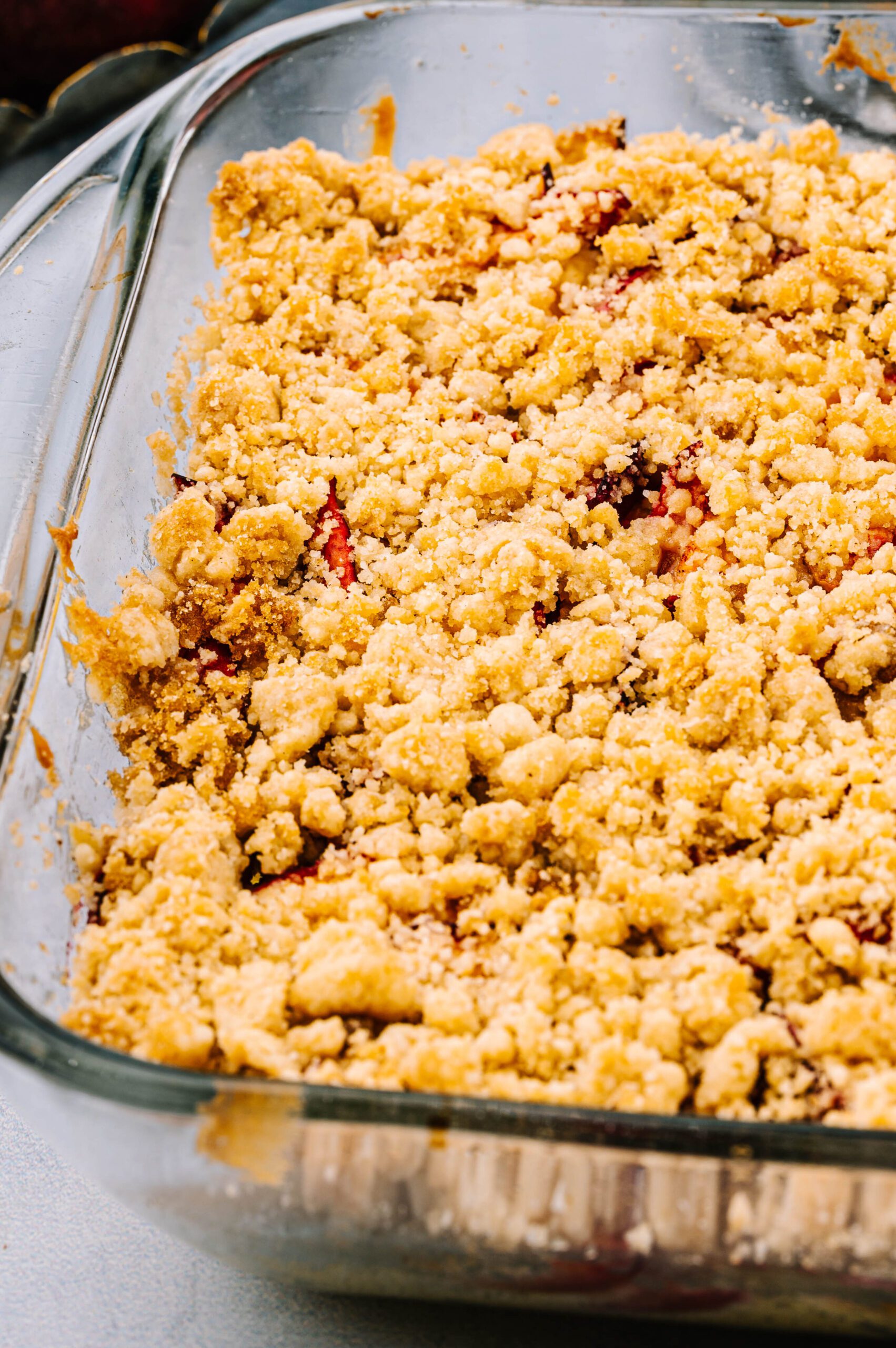 close up of peach coffee cake in baking dish before baking