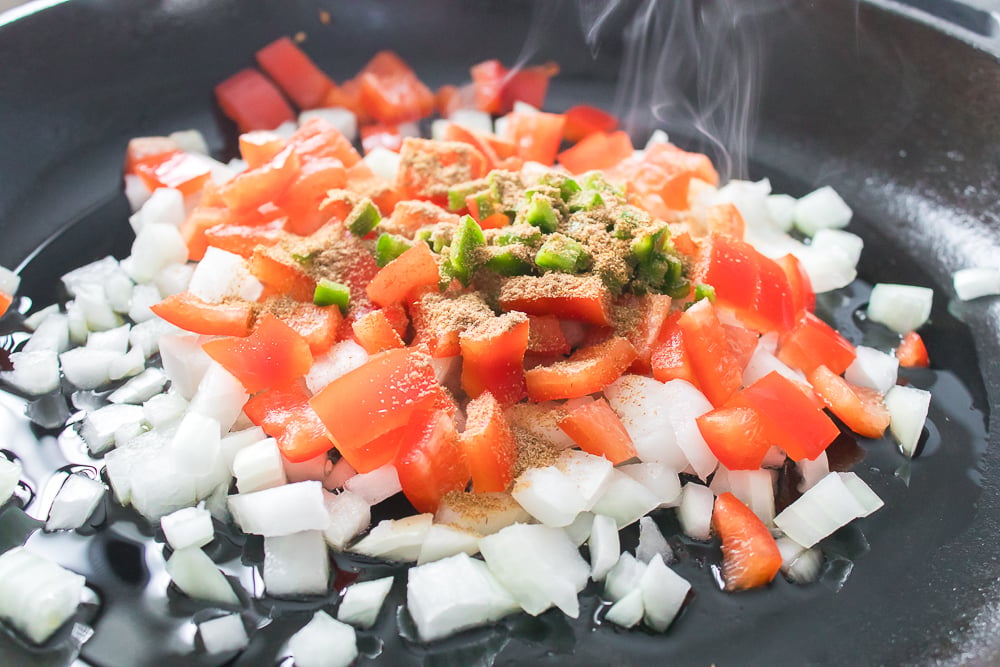 tomatoes, onions, peppers and seasoning in skillet