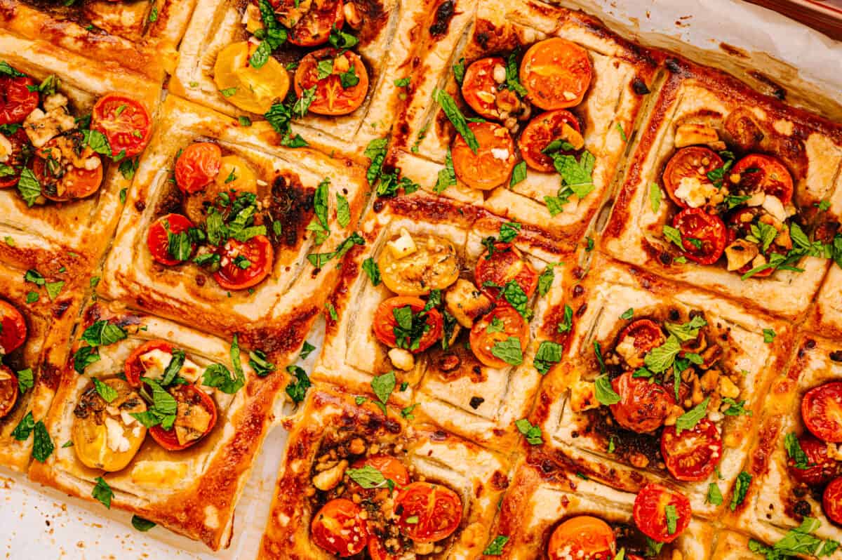 overhead close up shot of baked tomato tartlets topped with fresh mint