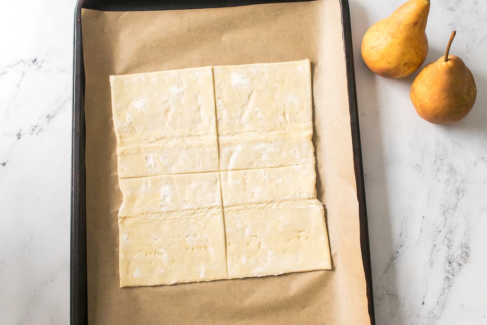 puff pastry on baking sheet cut into four squares