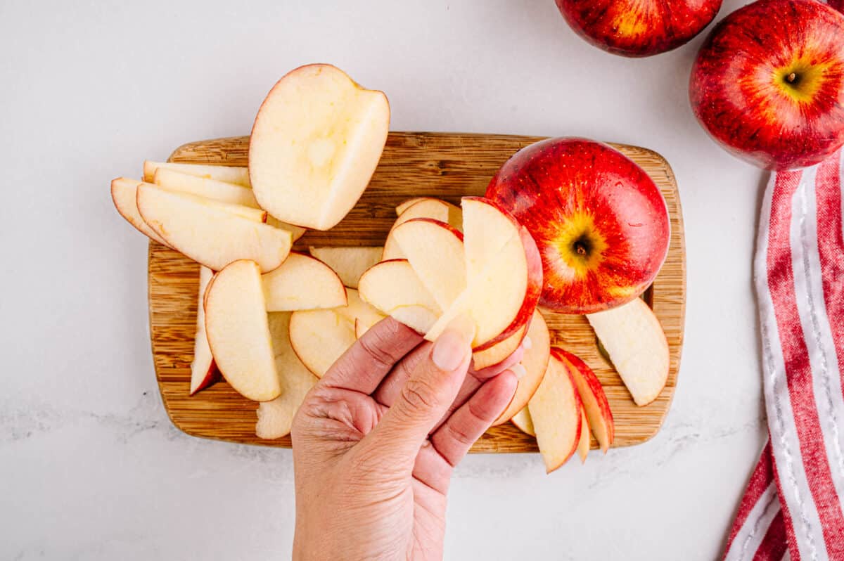 hand holding apple slices after being sliced