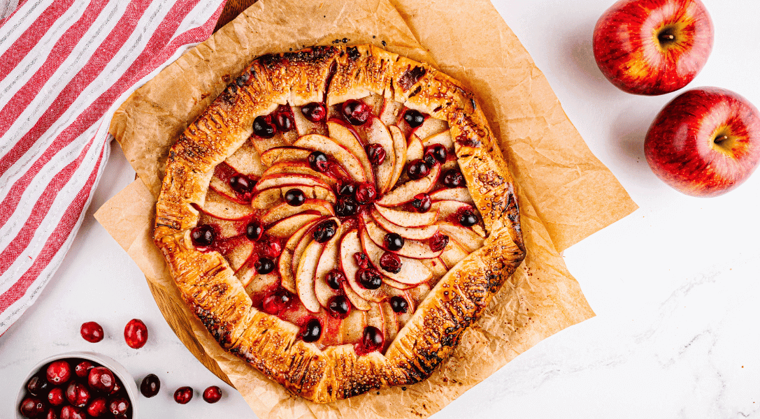 Overhead view of Cranberry Apple Galette with Envy™ apples and bowl of cranberries