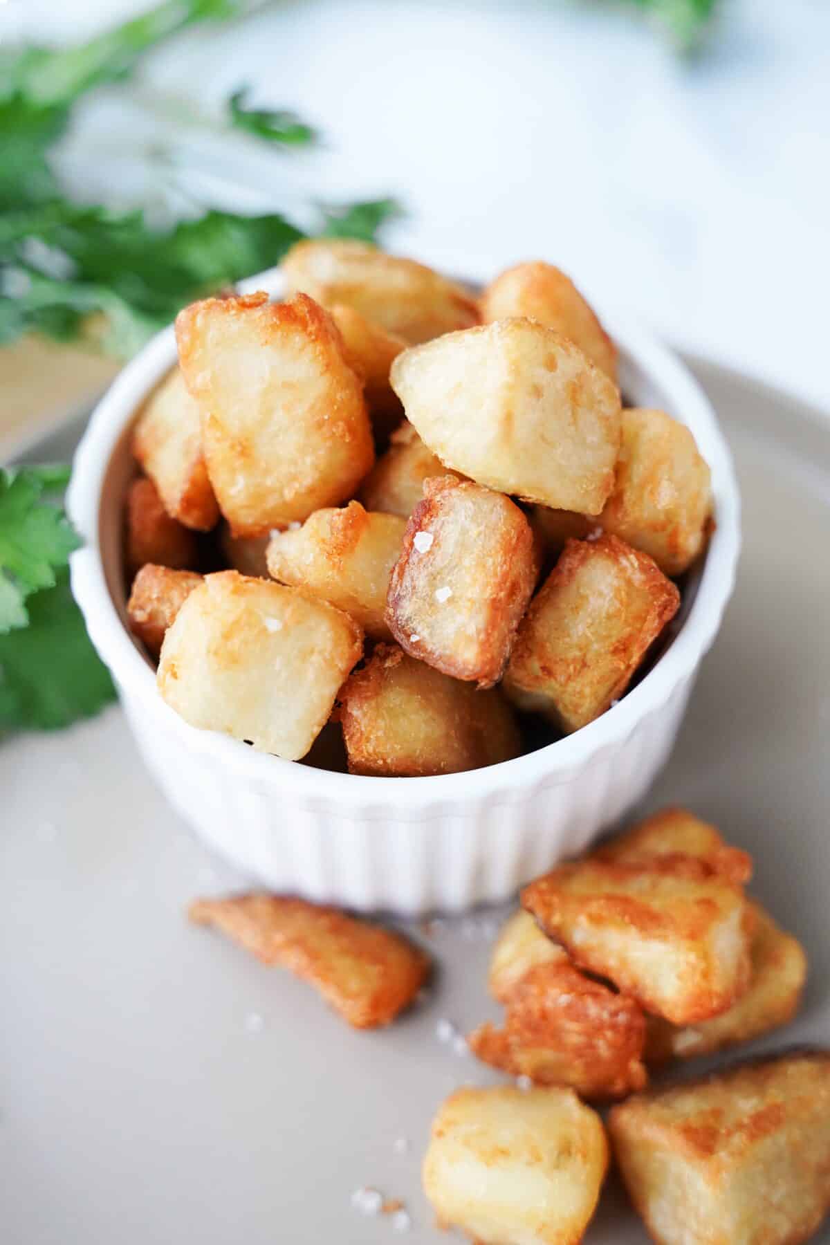 close up shot of patatas bravas in white serving dish
