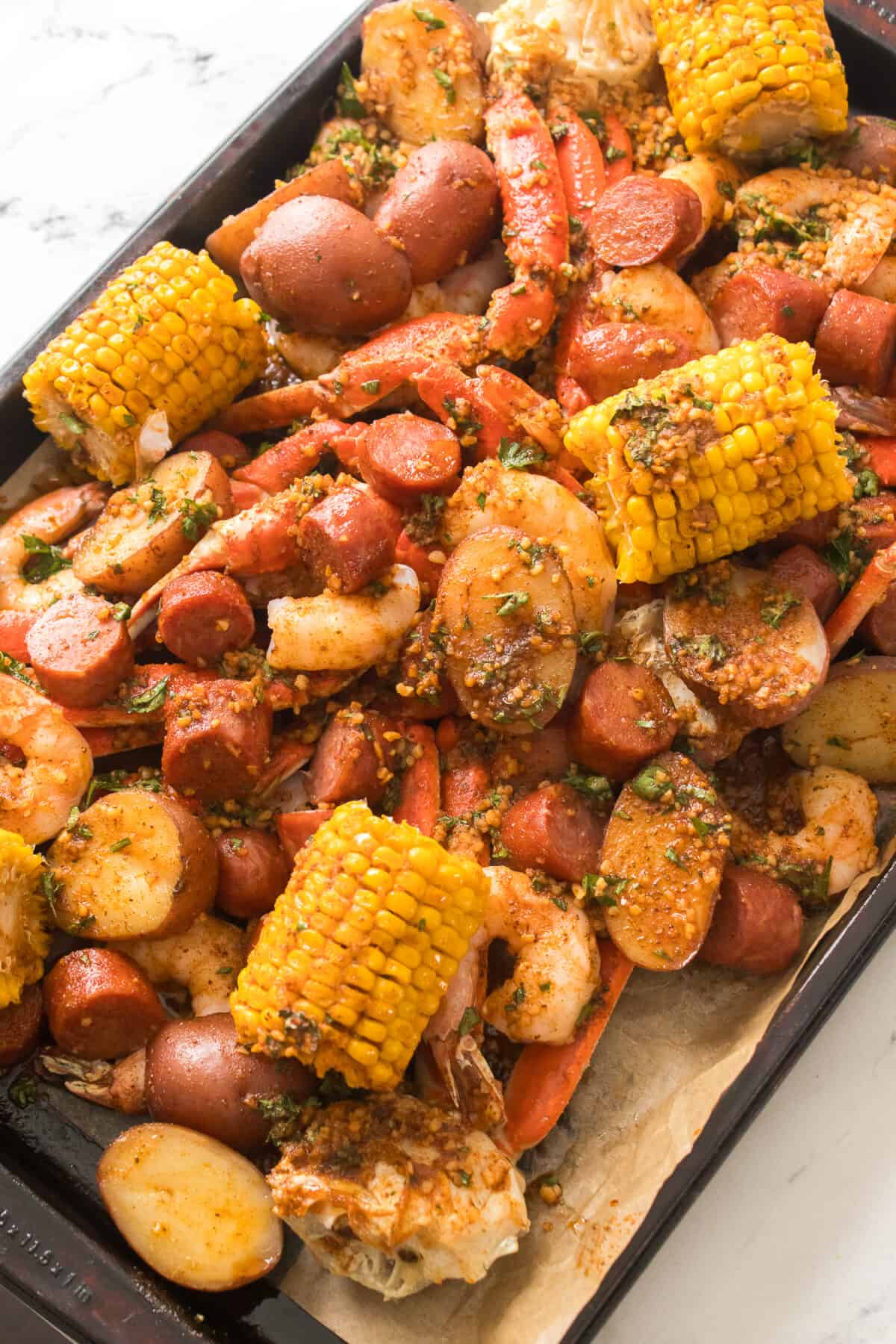 overhead shot of seafood boil that's been cooked on a sheet pan