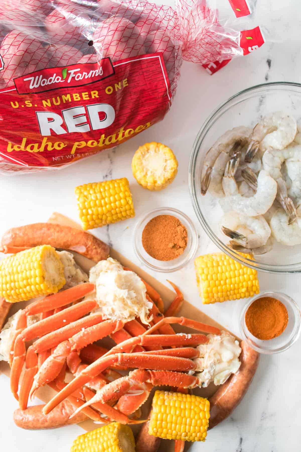 overhead shot of ingredients for seafood boil baked on a sheet pan