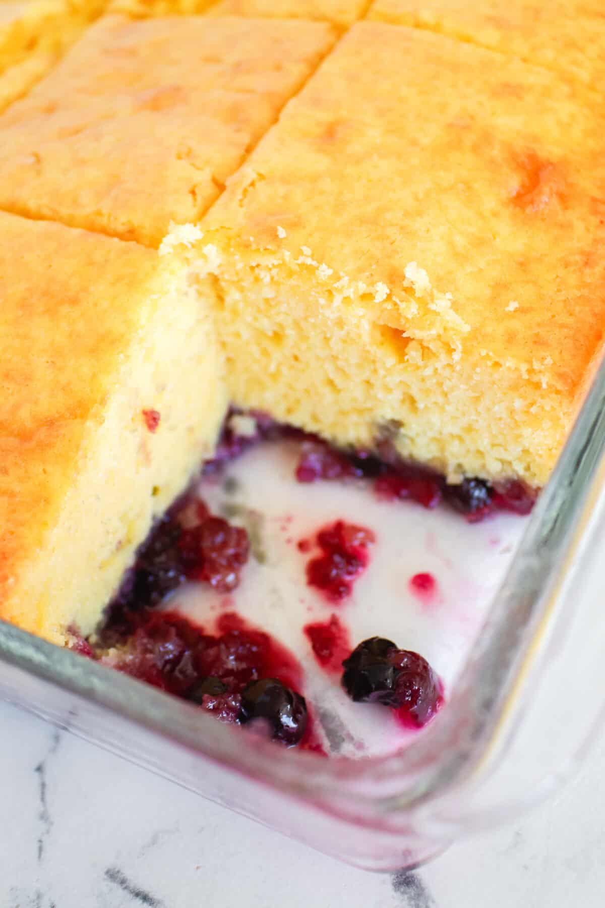 close up of cake in the baking dish with one serving out