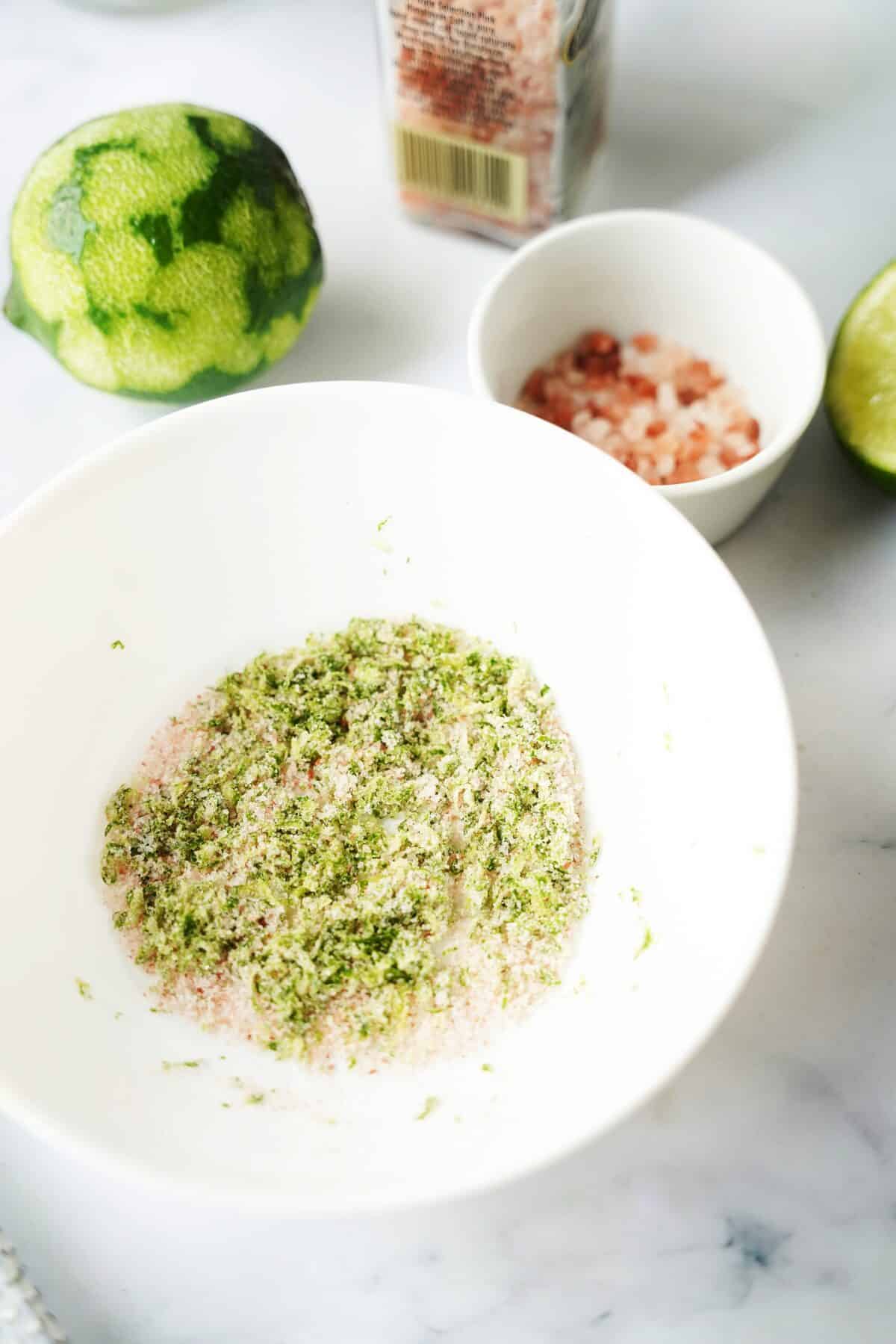 lime zest and salt mixed together in white bowl