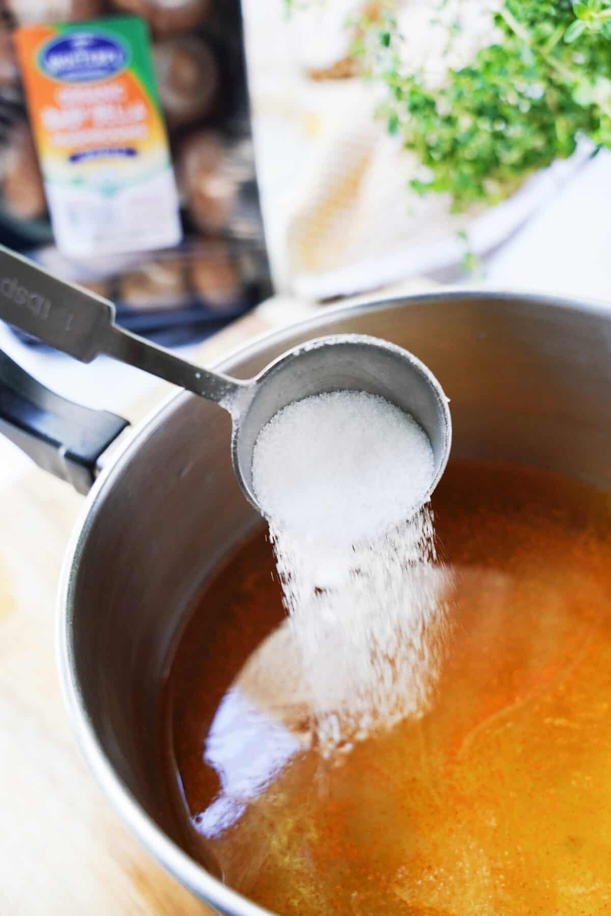 salt being added to sauce pan