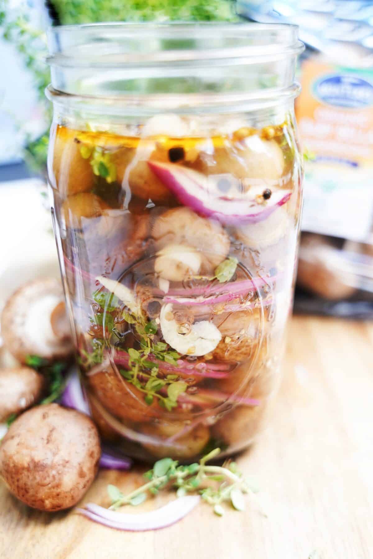head on vertical shot of pickled mushrooms in a mason jar