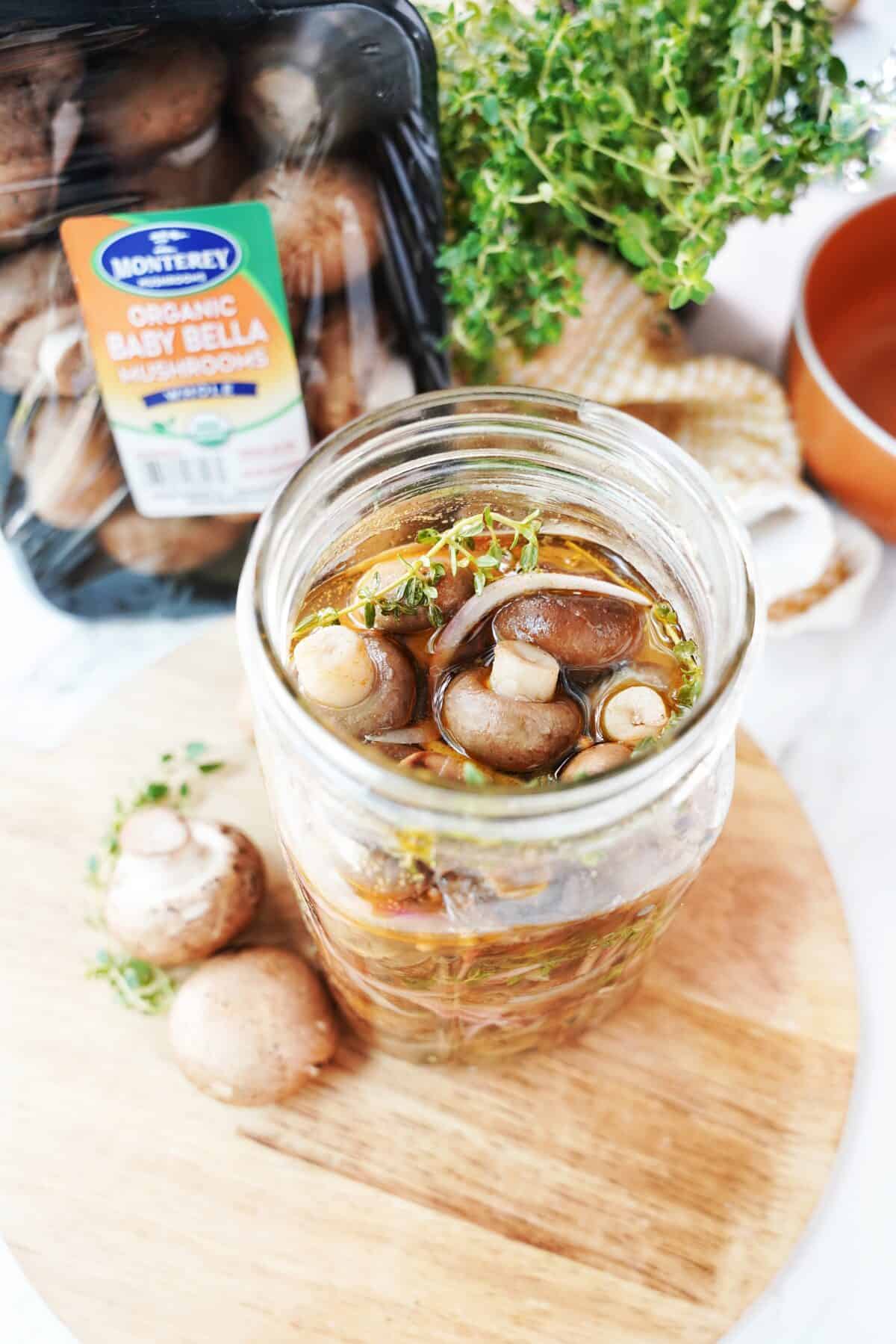 close up vertical shot of pickled mushrooms in a mason jar