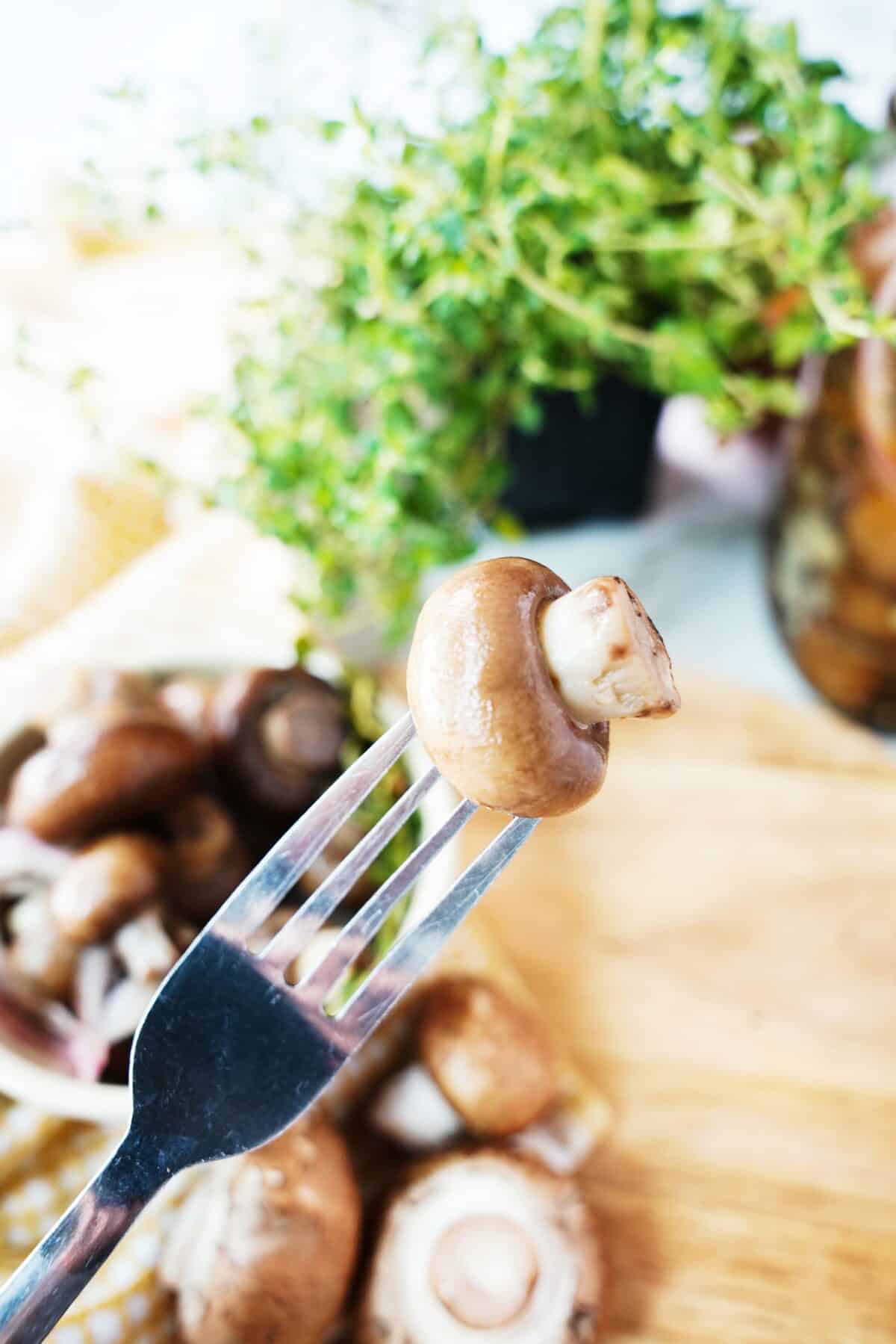 fork holiding a pickled mushroom