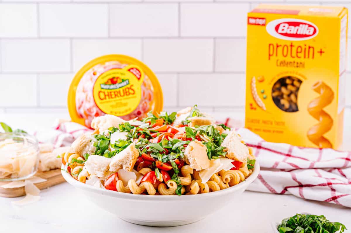 Bruschetta pasta salad with tomatoes and a box of pasta.