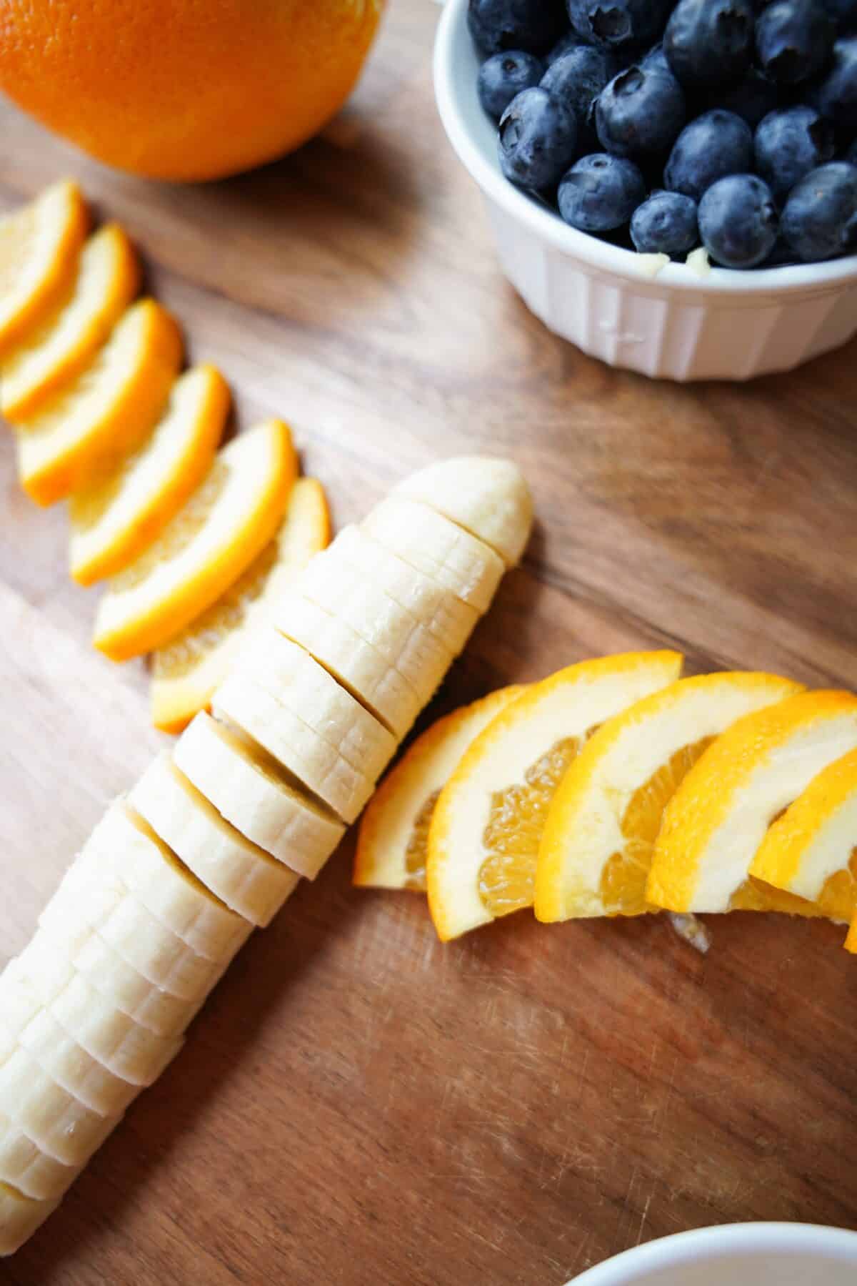 sliced banana with quartered slices of naval oranges spread into a fan to resemble a butterfly wing