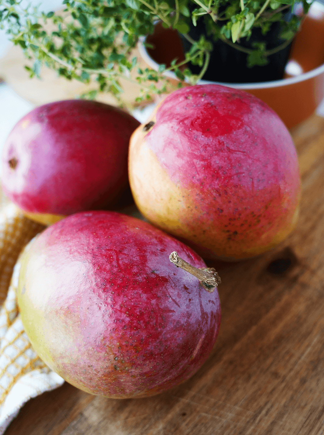 3 Mangoes on a wooden board