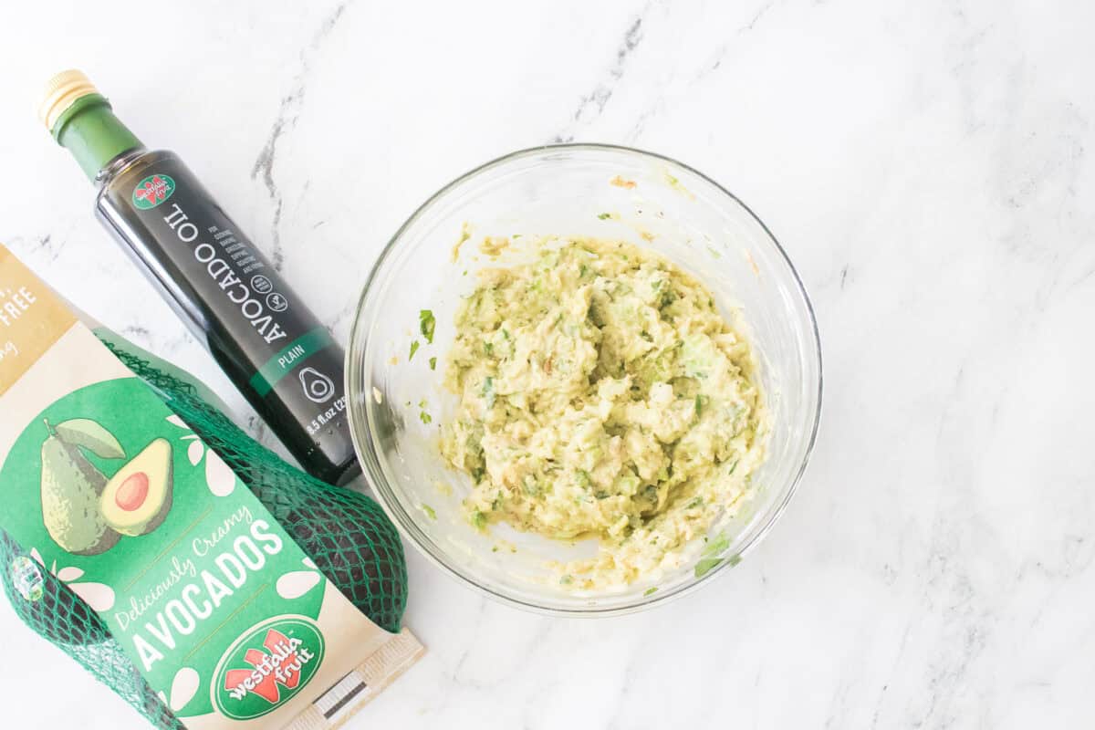 overhead shot of guacamole mixture in glass bowl