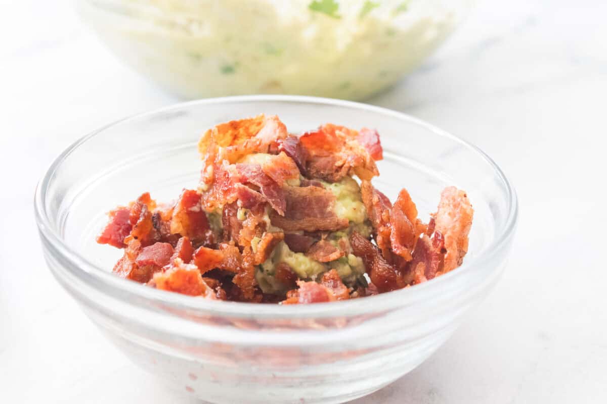 close up shot of guacamole in ball being covered in bacon