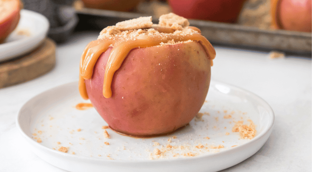 close up of cheesecake stuffed baked apple on a white plate