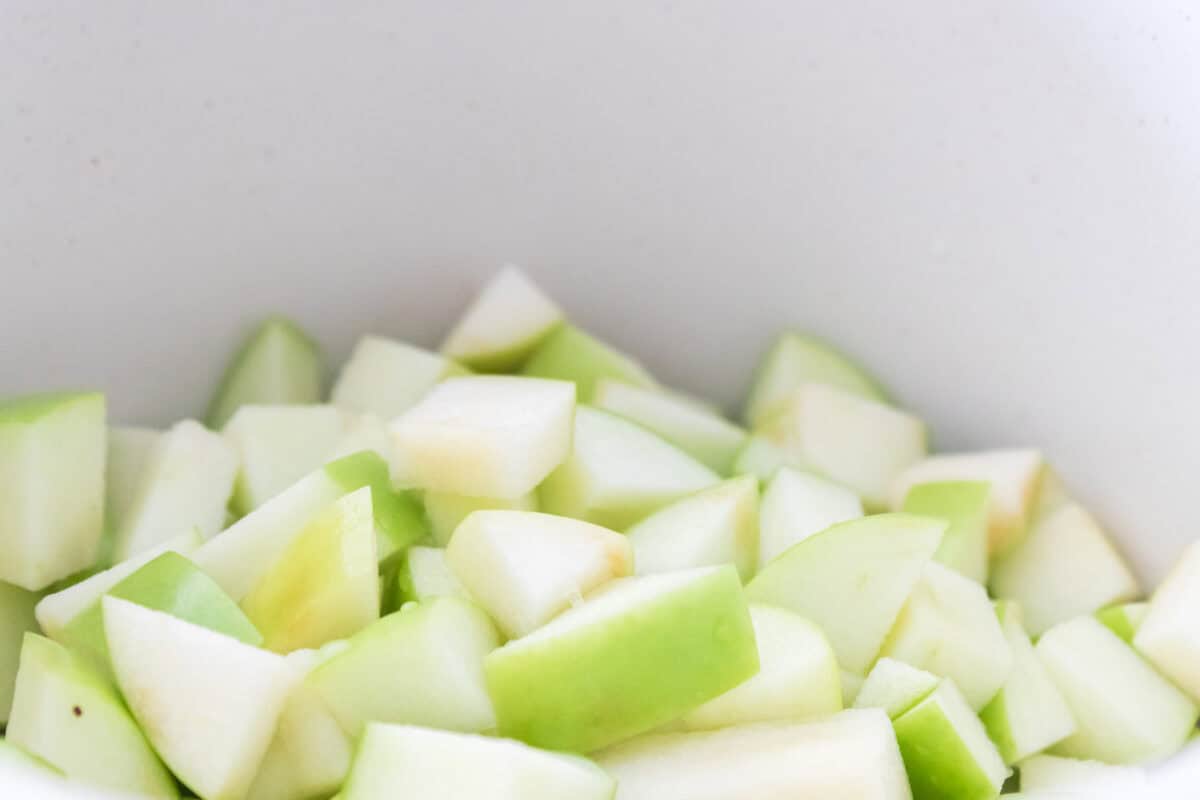 close up shot of diced granny smith apples in a sauce pan