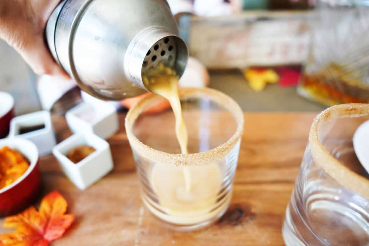 Pouring Pumpkin Spice Cocktail from shaker to glass