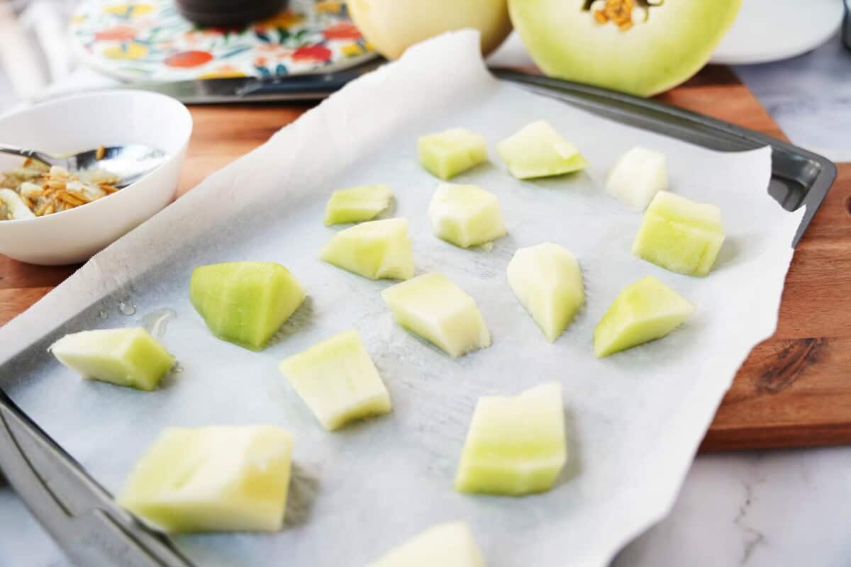 chunks of honeydew melon on a lined sheet