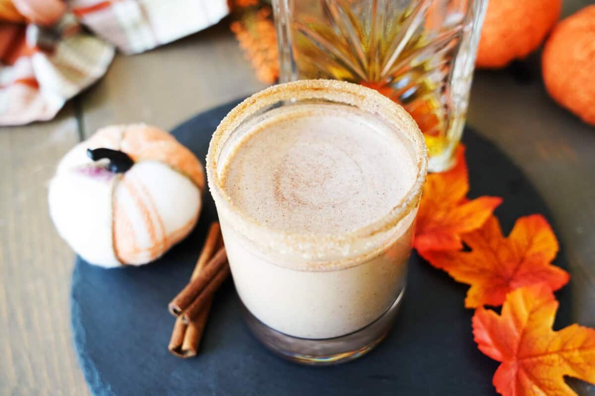 Pumpkin Spice Cocktail Shot on plate with pumpkins and fall leaves
