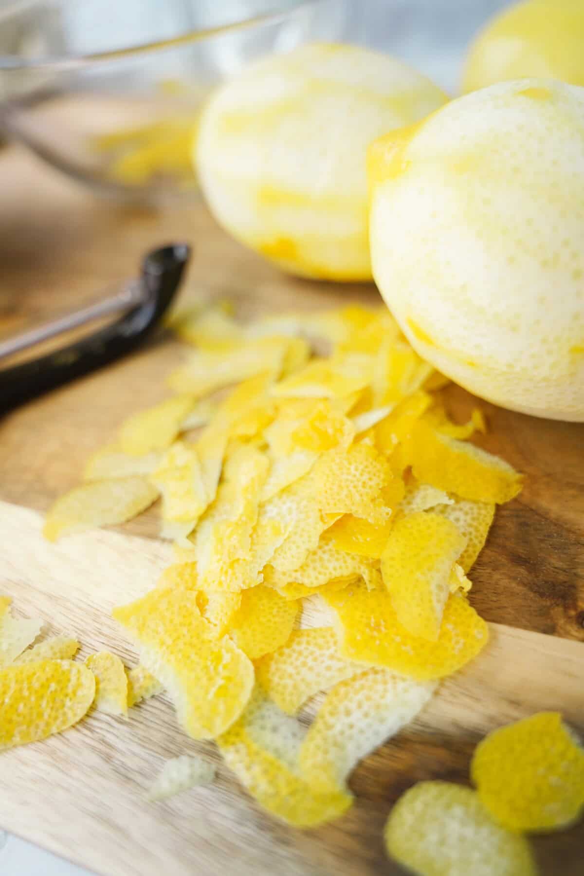 Peeled lemon pieces on a cutting board.