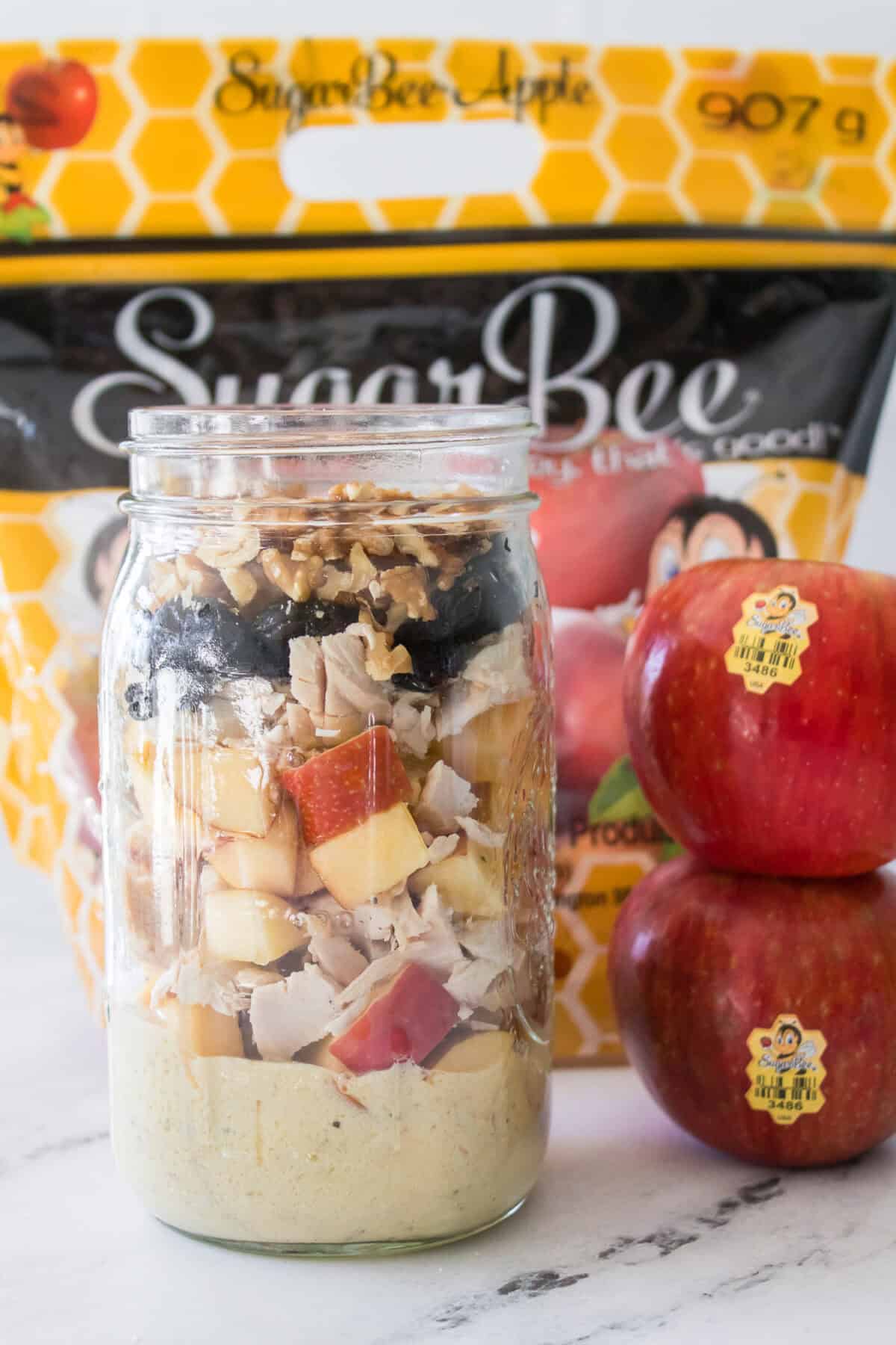 close up shot of layers of apple chicken salad in mason jar