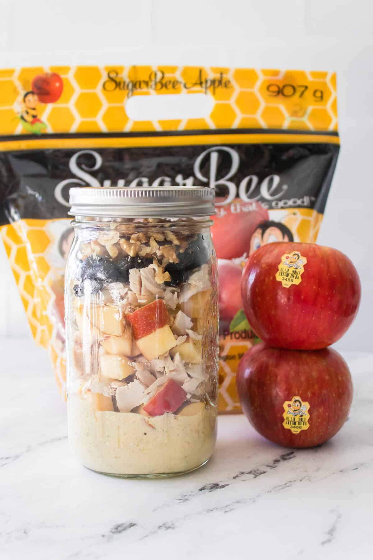 close up vertical shot of apple chicken salad in mason jar
