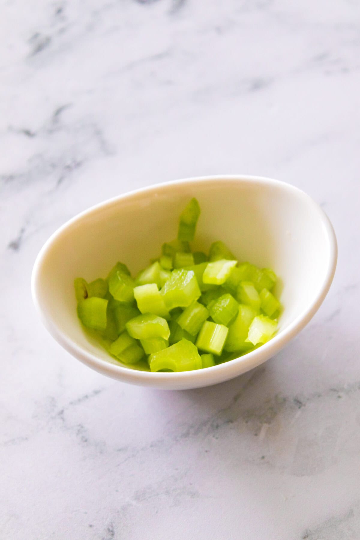 diced celery in white bowl
