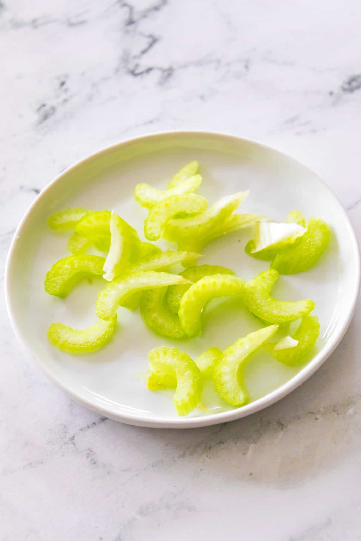 biased cut of celery pieces on white plate